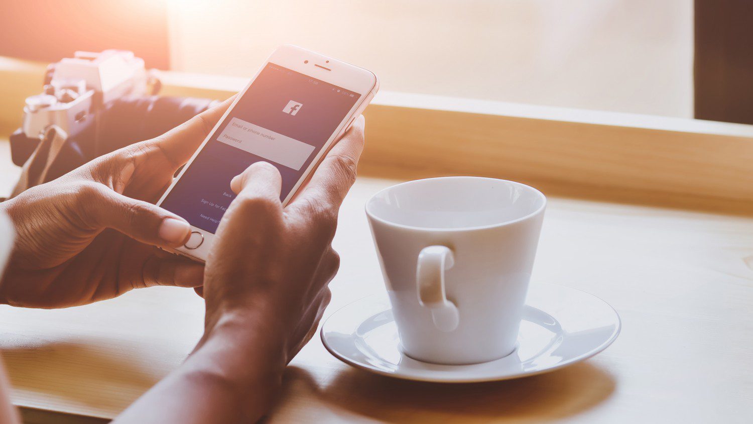 person holding mobile phone with coffee