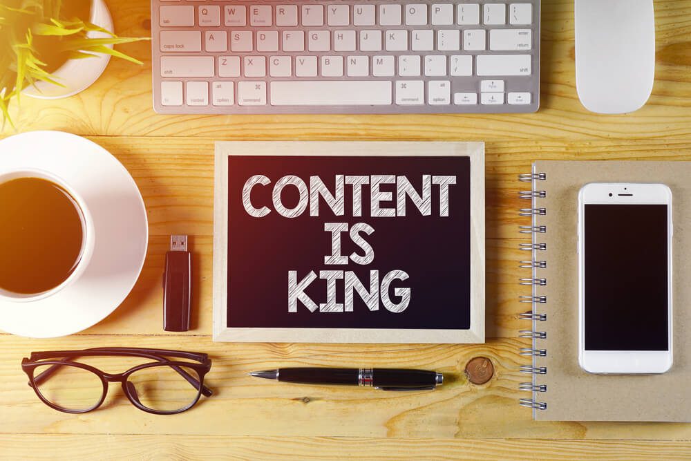 small chalk board on desk that reads: content is king