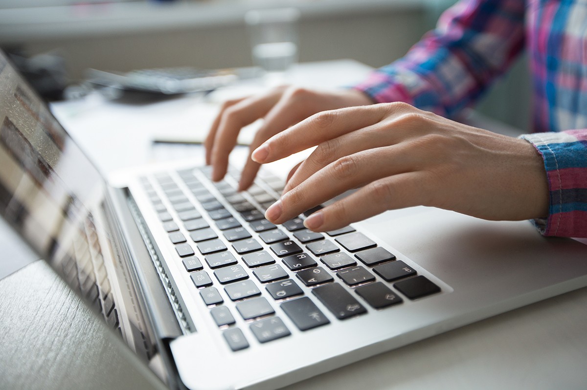 person typing on laptop for blog