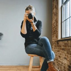 Morgan Kropa posing with her camera in the Ladybugz office